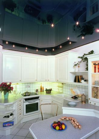 Como en el caso de las placas de yeso, los techos tensados ​​para la cocina se ven mucho más impresionantes con una iluminación bien montada.
