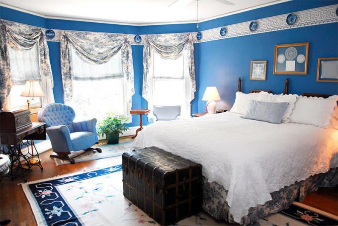 Foto de un dormitorio con paredes azules para reducir el espacio.