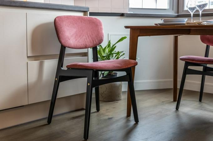 Acomodar la mesa de comedor invitan cuatro sillas de madera contrachapada de abedul revestido con un esmalte resistente a la humedad, con respaldos y asientos tapizados en rica tonalidad rosada.