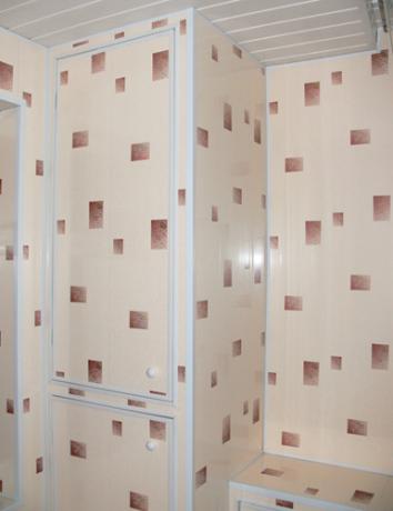 Aplicación de paneles de PVC para revestimiento de paredes y armarios en la cocina.