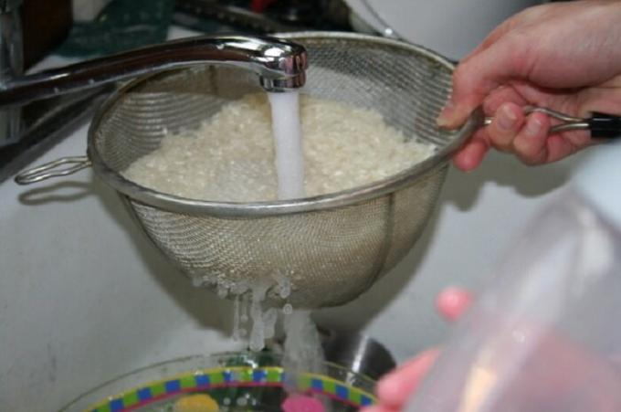 Lavar el arroz en un colador cómodo con agua corriente.