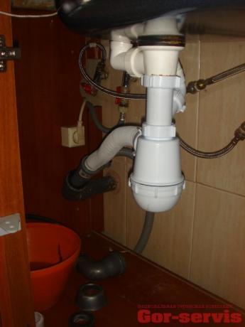 Organización correcta del ángulo de drenaje desde el sifón hasta la tubería de alcantarillado, realizado con una manguera corrugada